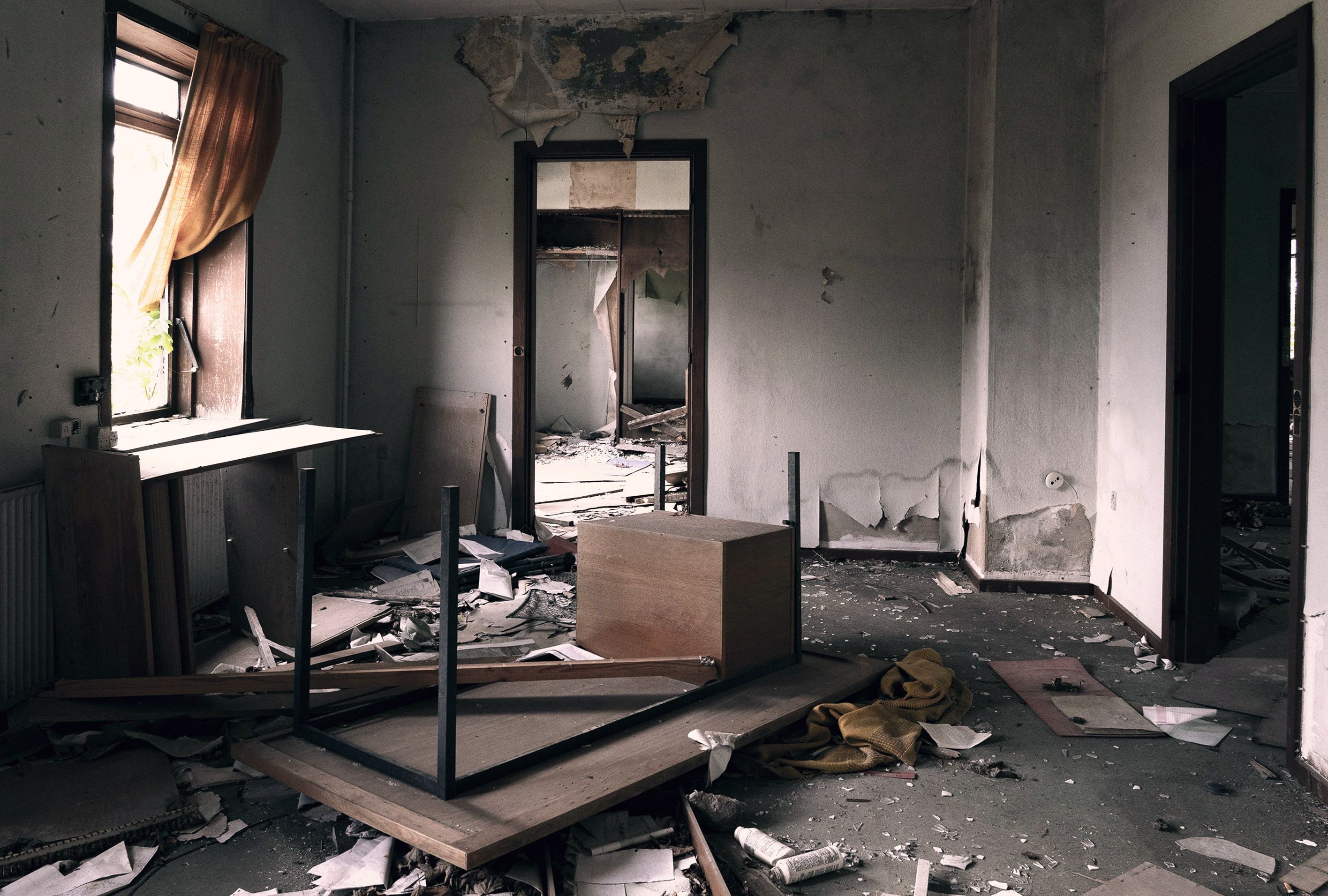 A messy, derelict room, suggesting a squatted property before intervention.
